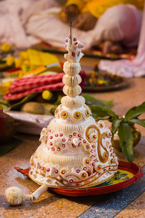 topor is a conical headgear made of white sholapith which is worn by Bengali groom during...