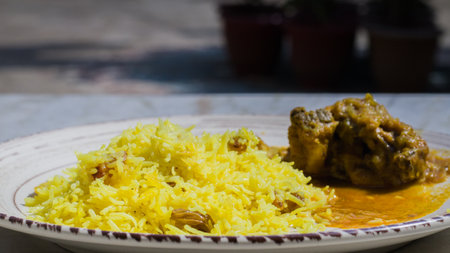 Pulav and chicken curry served on a plate. Traditional Bengali basanti polao or misti polao or fried...