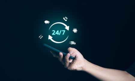 Man hand holding phone with icon virtual 24-7 on for worldwide nonstop and full-time available contact of service concept. Assistance customer services, deliver, and Nonstop service 24 hr concept.の写真素材