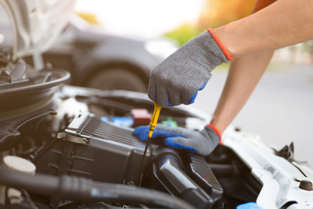 Man checking level of engine oil. Car Repairs, vehicle maintenance, car mechanic, Car inspection and maintenance concept.の写真素材