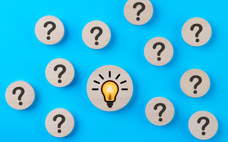 Problem solving concept. Question mark and light bulb icons on round wooden on blue background. Creative thinking, innovation, and idea, Business solution company, Find solution, Step idea process,の写真素材