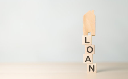 Real estate loan concept. House model on wooden cube block loan wording stacking. Risk management in...
