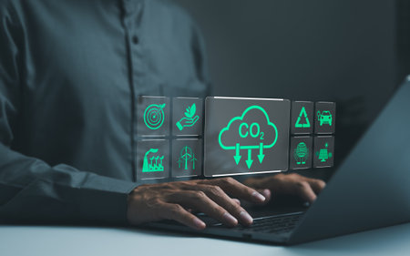 Businessman use laptop computer with environmental carbon reduction icons. Technology net zero,...