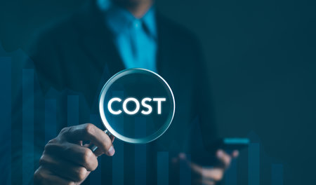 Cost Analysis and Management Concept. Businessman holding magnifying glass highlighting the word "COST" symbolizing cost analysis, reduction, and management in business operations. Effective business,の写真素材