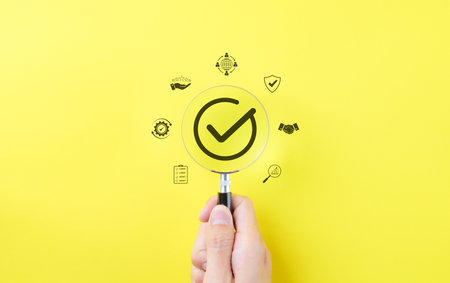 Quality Assurance Concept, Compliance Check Mark. Hand holding magnifying glass with a check mark...