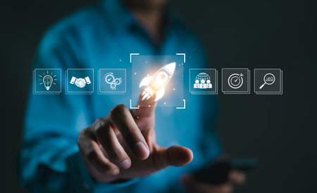Business Growth and Startup Success Concept. A hand touching rocket icon on digital interface, symbolizing business growth, startup success, innovation, and achieving goals through strategic planning.の写真素材