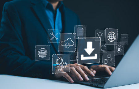 Digital Download and Data Storage Technology. Businessman using laptop with digital icons represent data download, cloud storage, networking, and system maintenance. Focus is on technology in businessの写真素材