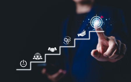 Business Growth and Success Strategy Concept. Businessman points at target icon at top of staircase, step-by-step strategy, and achieving goals. goal setting, strategic planning, business ventures,の写真素材