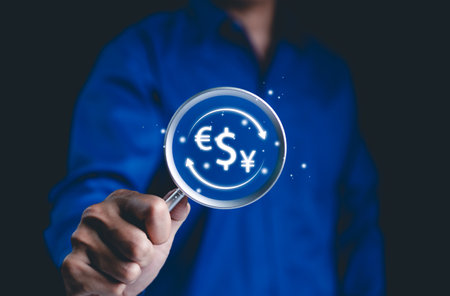 Currency Exchange and Global Finance Concept. Businessman holds magnifying glass with symbols dollar, euro, yen, currency exchange and international finance. global currency markets, foreign exchange,の写真素材