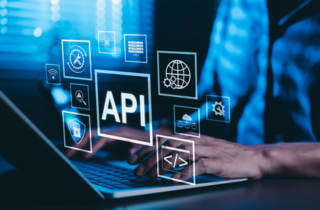 API Application Programming Interface Concept. A programmer types on a laptop, interacting with digital icons representing API development, security, and cloud computing. Application Software Tool,の写真素材