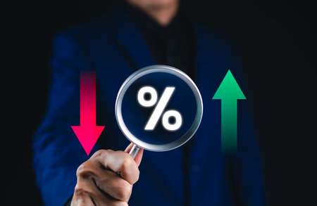 Financial interest rate and market trends concept. Businessman holding magnifying glass with...
