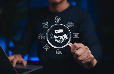 AI and human collaboration concept. Person holds magnifying glass focusing on handshake between robot and human, surrounded by technology icons, artificial intelligence collaboration and partnership.の写真素材
