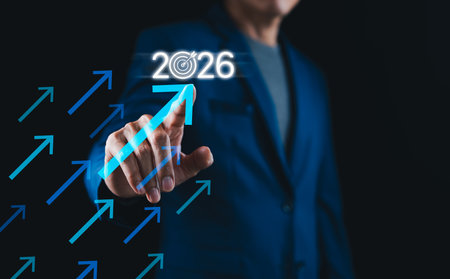 Businessman pointing at 2026 with upward arrows symbolizing growth, goal achievement, and strategic...