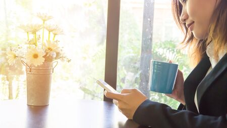Woman use of smart phone in coffee shopの写真素材