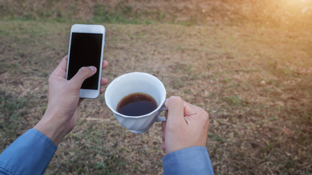 Man Mobile smartphone with hot coffee.の写真素材