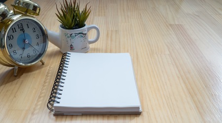Notebooks, alarm clocks, vases on wooden board