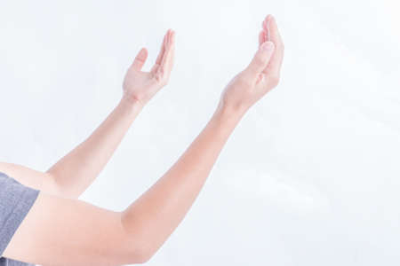 Portrait of a woman raising her hand on a white background.の写真素材