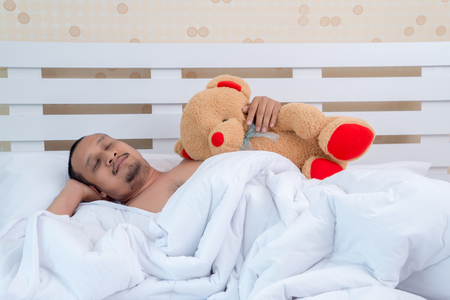 A good looking man sleeps innocently in bed before work.の写真素材
