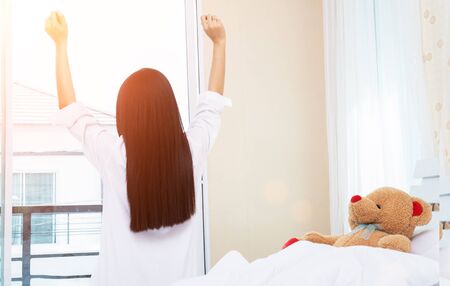 Woman Stretching In Bed After Wake Up, Back Viewの写真素材