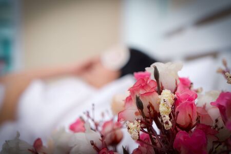 Flower bedside table by bed in bedroom Beautiful girl sleep peacefully in bed.の写真素材