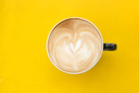 Hot coffee cup on yellow table latte art coffeeの写真素材