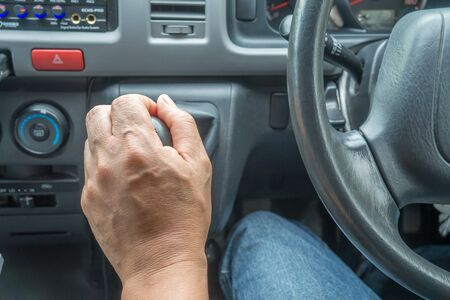 a man holding gear handle of the car with left hand