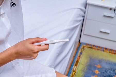 Closeup on young woman looking on pregnancy testの写真素材