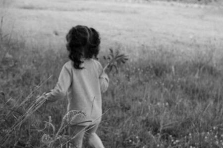 Cute little boy running in the lawn is black and white, blurred image.の写真素材