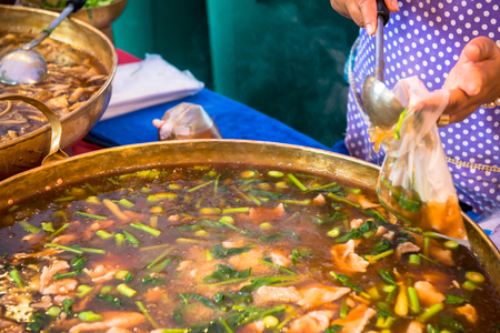 Popular Thai noodles, stir fried kale and fermented pork in soup with carrots, corn, mushroomsの写真素材