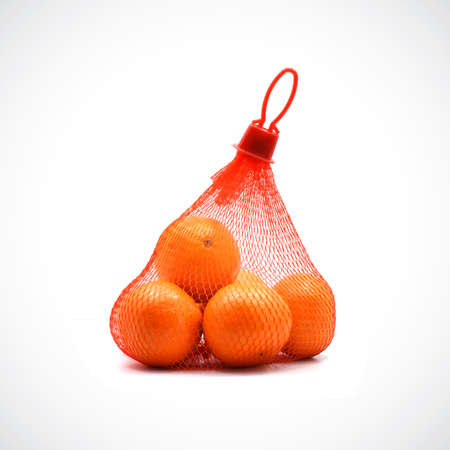 Fresh oranges inside a mesh bag are available for sale.の写真素材