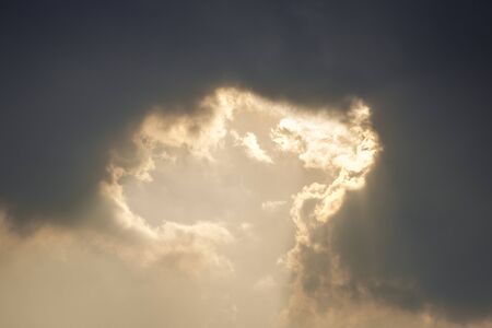 Golden sunlight ray shining throught dark clouds.