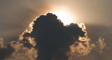 Golden sunlight ray shining throught dark clouds.の写真素材