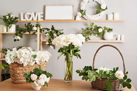 Floral background. Flower shop interior. Floral design studio, making decorations and arrangements. Flowers delivery service and sale of home plant, creating order. Peonies and rosesの写真素材