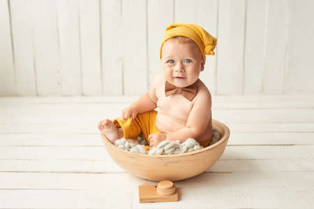 Baby boy sitting on crib. Children Protection Day. Happy childhood. Early child development. Educational toys. Mother's day card. Child plays with toys. Happy babyの写真素材