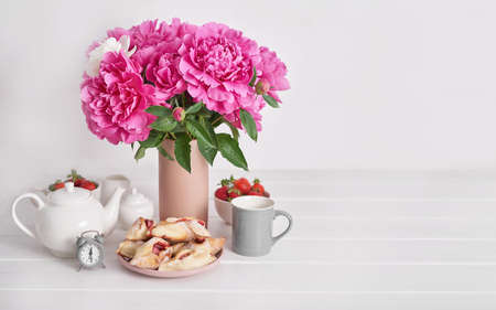 Strawberries and peonies flowers. Romantic breakfast at hotel. Mother's Day Greeting Card. Tea set and buns with strawberries. Cozy morning. Valentine's Day. Sweet dessert. Good morning!の写真素材