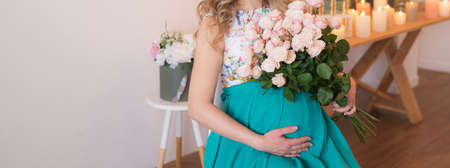 Pregnant woman holds hands on belly. Pregnancy, maternity, preparation and expectation concept. Close-up, copy space. Beautiful tender mood photo of pregnancy.の写真素材