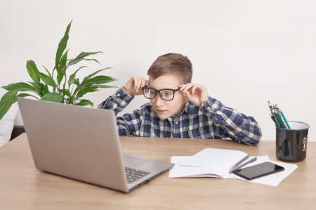 Online lesson at home, social distance during quarantine, self-isolation, online education concept, home schooler. Boy learning language online, using laptop, distance education. Student boy, school.の写真素材