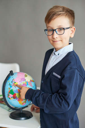 Back to school. Funny little schoolboy in glasses performs tasks. Child from elementary school with...