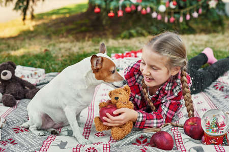Family Christmas in July. Portrait of girl near christmas tree with dog. Baby decorating pine....