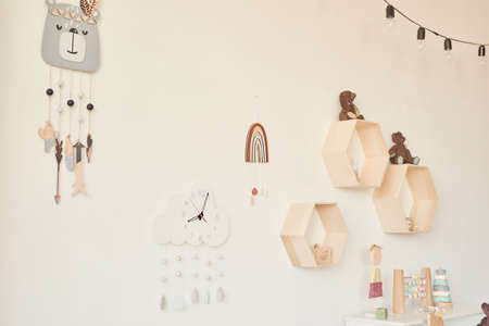 Kids room scandinavia. Wooden toys in children's room, chest of drawers and white bed, interior of...