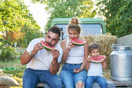Family on farm.Harvesting Watermelons. Pickup with watermelons. Picnic on farm.Family day.Mother and father's day greeting card.Organic Farming, Food and Vegetable Production.Bio food. Garden produceの写真素材