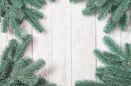 Christmas tree background. Pine branches on white wooden background. Flat lay. Copy space. Happy New Year greeting card. Christmas and New Year holiday. Fluffy fir tree. Winter holidays and vacationsの写真素材