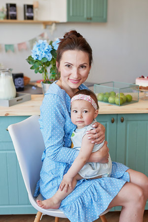 Portrait of a happy mother with her daughter at home in the kitchenの写真素材