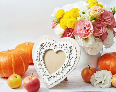 Autumn harvest pumpkin background. Pumpkins, apples and flowers on table. Thanksgiving table. Copy...