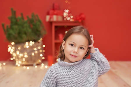 Christmas baby. Child girl with gifts on background of Christmas tree. Xmas greeting card. Merry christmas background. Happy New Year! Winter celebrations, holidays and vacationsの写真素材