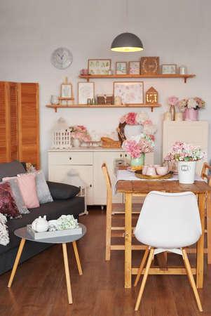 Pink living room and kitchen. Studio apartment. loft interior. Shelves and spring decor in the room....