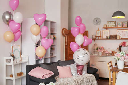 Valentine's Day. International Day of Happiness. Studio apartment in loft style. holiday decor. Pink balloons and flowersの写真素材