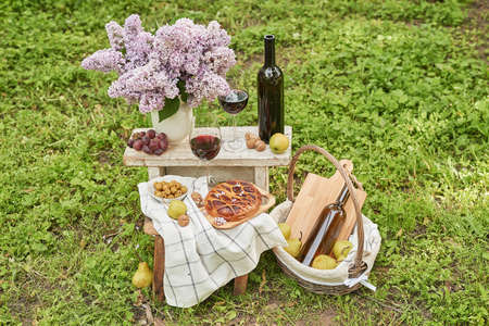 Summer picnic in the garden. Wine, pie, fruits and flowers. still life. Easter lunch and table.