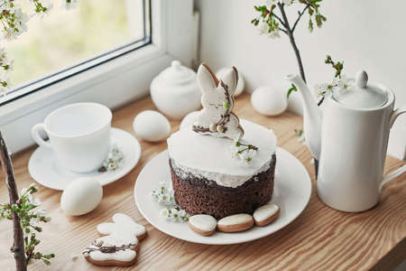 Celebration and holiday. Easter cake with gingerbread, homemade cake, eggs. Easter bunny and flowering branches postcard.の写真素材