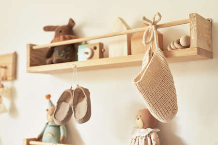 Children's knitted clothes on hanger. Jacket, jumper, hat, shoes. toys. Children's room, nursery.の写真素材